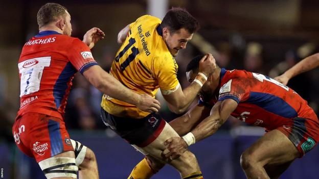 Jacob Stockdale is tackled by Sam Underhill and Joe Cokanasiga