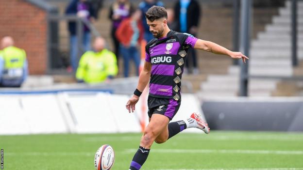 Adam Hastings kicks the ball during Gloucester's match with Barbarians