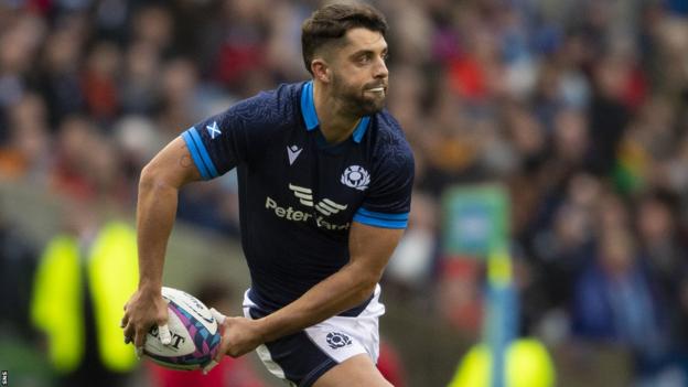 Adam Hastings pass the ball while playing for Scotland