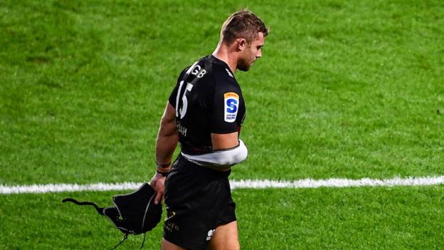 Leigh Halfpenny of Crusaders leaves the field after picking up an injury during the friendly against Munster