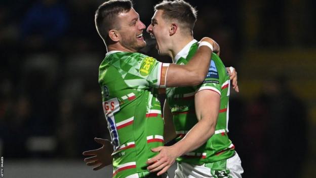 Jack van Poortvliet is congratulated by fellow Leicester half-back Handre Pollard after scoring the opening try at Newcastle