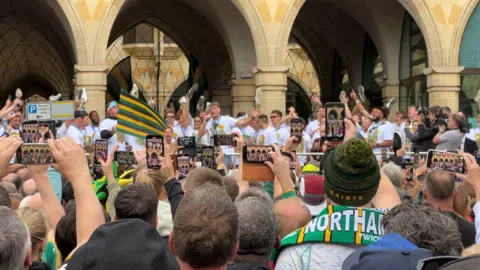 Harriet Heywood/BBC Saints players sing to fans 