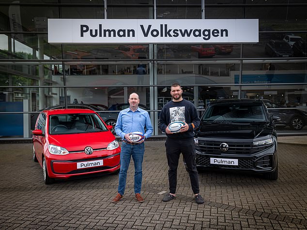 Martin pictured (right) recently posing for a photo at a Pulman Volkswagen dealership