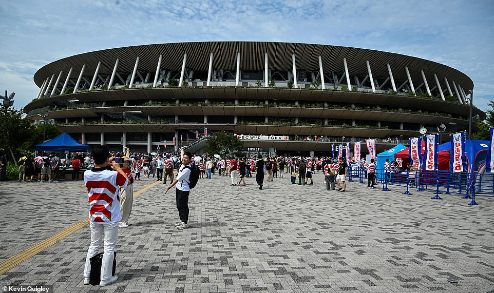 Fans pose for pictures outside the grand venue in the Japanese capital to make sure they have a moment to mark the occasion