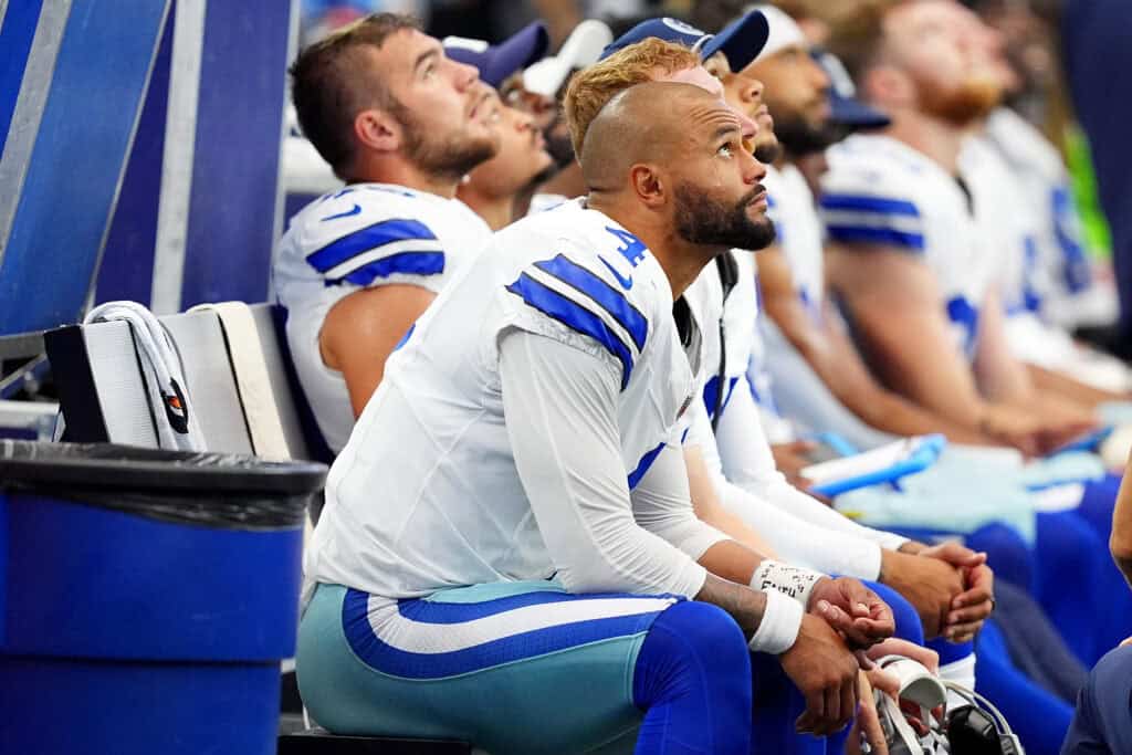 ARLINGTON, TEXAS - SEPTEMBER 15: Dak Prescott #4 of the Dallas Cowboys rests on the bench during the fourth quarter against the New Orleans Saints at AT&T Stadium on September 15, 2024 in Arlington, Texas.