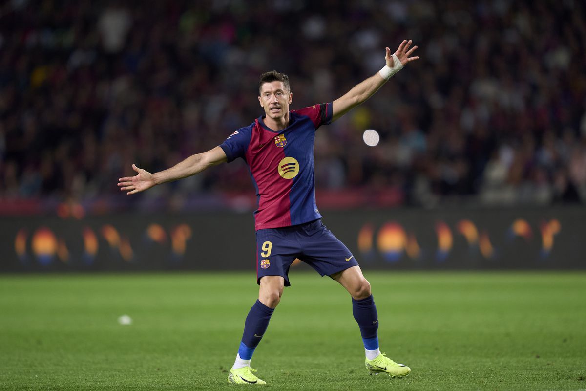 Robert Lewandowski, both arms outstretched, gestures towards a teammate during Barcelona’s win over Sevilla at the weekend.