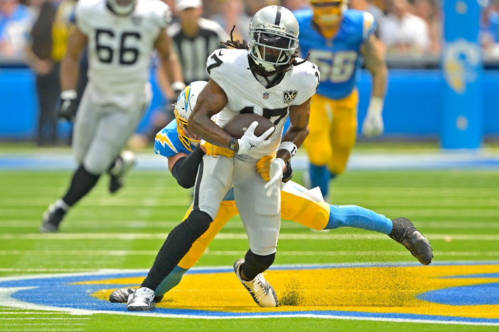 Las Vegas Raiders wide receiver Davante Adams (17) is stopped by Los Angeles Chargers safety Alohi Gilman (32) after a compete pass in the first half at SoFi Stadium.