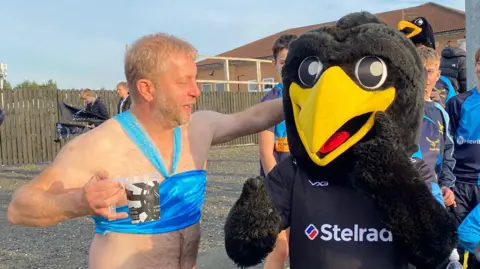 Supplied A man with a beer dressed as Princess Jasmine larking about with a person dressed as a giant black bird