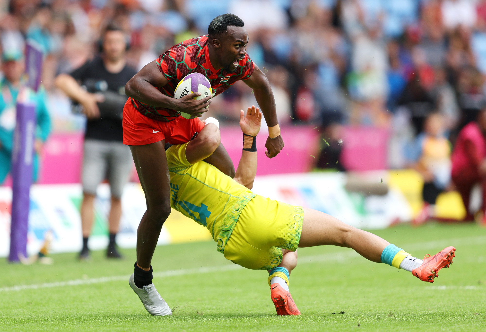 Edmund Anya of Team Kenya is tackled by Dietrich Roache of Team Australia.