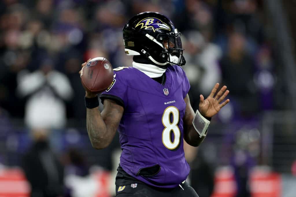 BALTIMORE, MARYLAND - JANUARY 20: Quarterback Lamar Jackson #8 of the Baltimore Ravens rolls out to pass against the Houston Texans at M&T Bank Stadium on January 20, 2024 in Baltimore, Maryland.