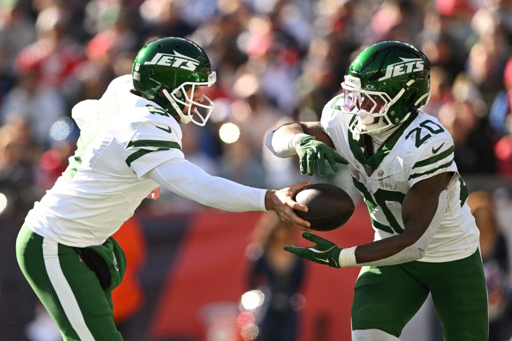 New York Jets quarterback Aaron Rodgers (8) hands the ball off to running back Breece Hall (20) during the first half at Gillette Stadium.