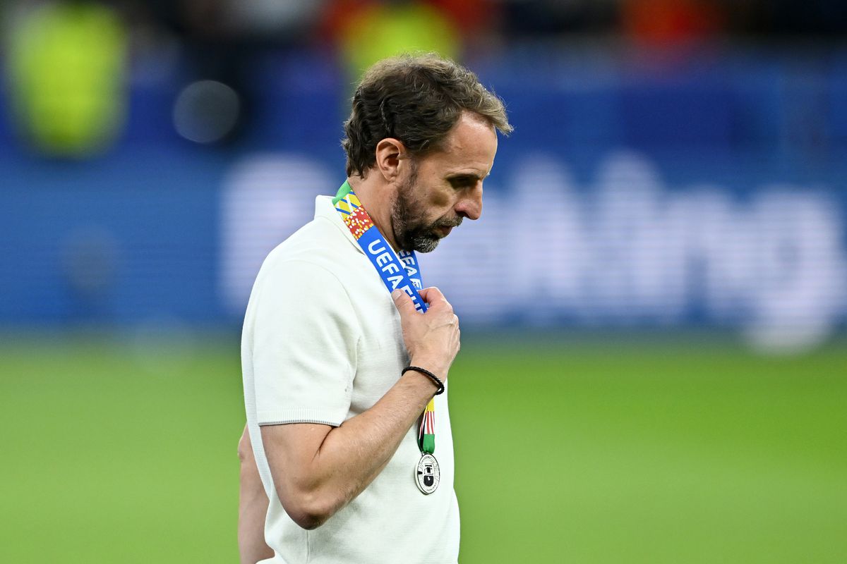 Gareth Southgate, looking dejected, walks past the UEFA 2024 trophy (not pictured) while wearing a runner’s up medal after Spain’s EURO 2024 Final victory over England.