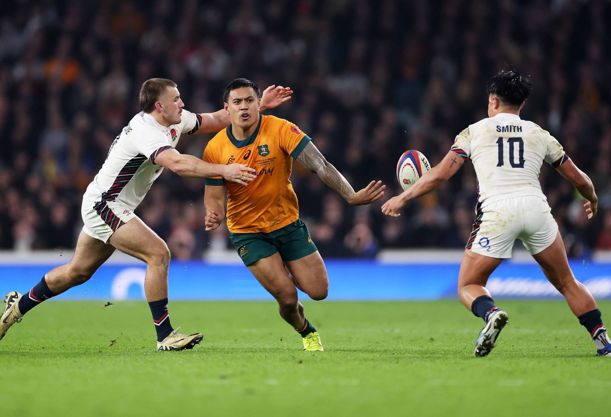 Len Ikitau of Australia passes the ball whilst under pressure from Ollie Sleightholme and Marcus Smith of England during the Autumn Nations Series 2025 match between England and Australia at Allianz Stadium on November 09, 2024 in London, England. (Photo by Julian Finney/Getty Images)