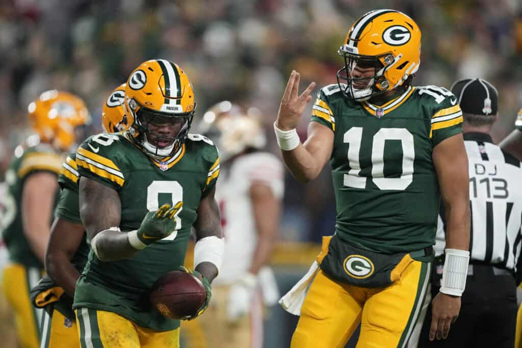 GREEN BAY, WISCONSIN - NOVEMBER 24: Josh Jacobs #8 and Jordan Love #10 of the Green Bay Packers celebrate after scoring a touchdown in the fourth quarter against the San Francisco 49ers at Lambeau Field on November 24, 2024 in Green Bay, Wisconsin. 