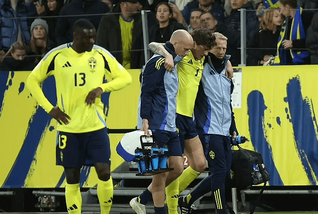 Lindelof being supported off the pitch against Slovakia