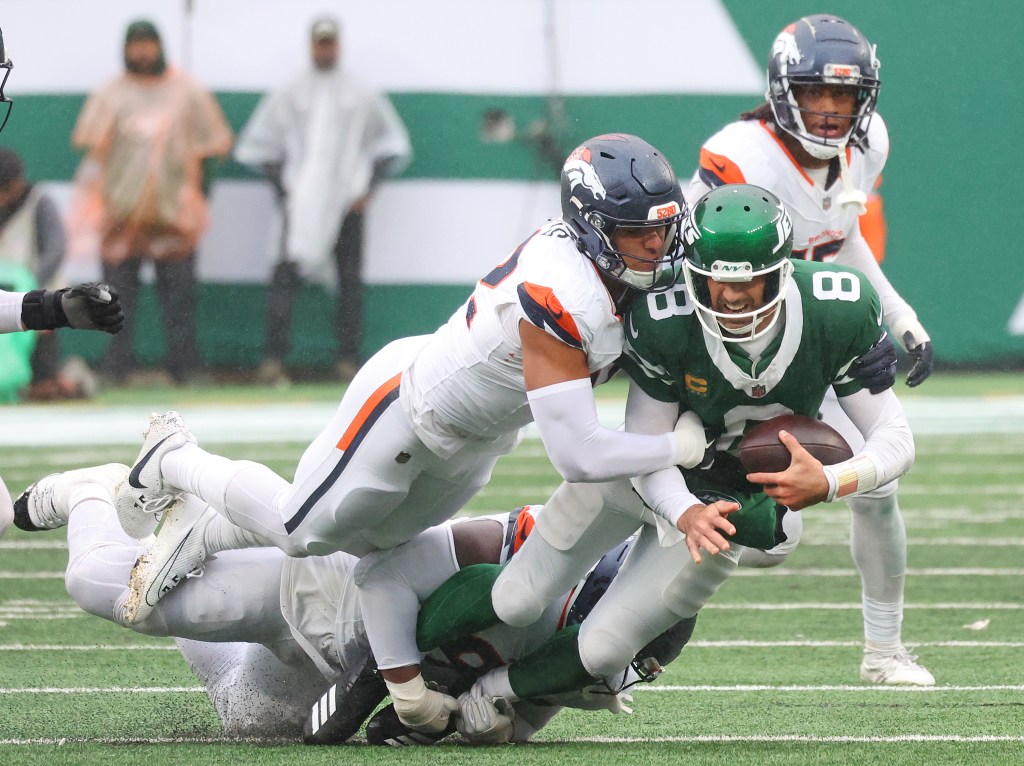 New York Jets quarterback Aaron Rodgers (8) gets sacked late in the fourth quarter when the New York Jets played the Denver Broncos Sunday, September 29, 2024 at MetLife Stadium in East Rutherford, NJ.