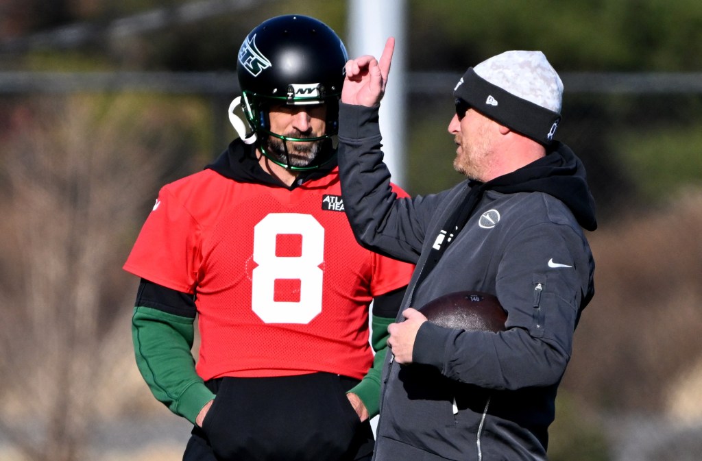 Todd Downing talks with Aaron Rodgers during a Jets' practice in November.