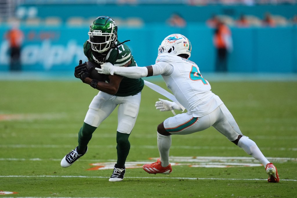 Dolphins cornerback Kader Kohou (4) attempts to tackle New York Jets wide receiver Davante Adams (17)