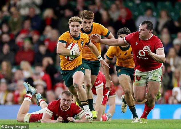 The thumping victory keeps the Aussies on track for a grand slam after they overcame England in a nail-biting finish last week (pictured, Tate McDermott runs the ball for the Wallabies)